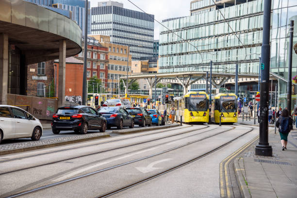 Front view of a tram, ready for boarding at a platform on a sunny day in central Birmingham, England.