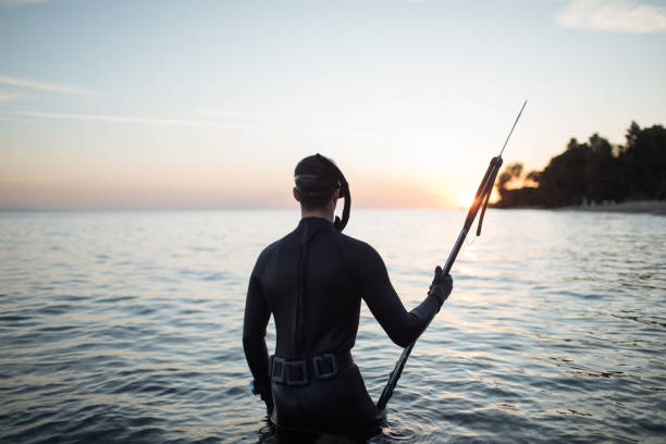 Silhouette of active man holding speargun