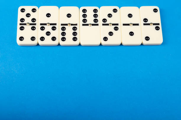 Dominoes with blue background, copy space and various angles. White Bones Board Game.
