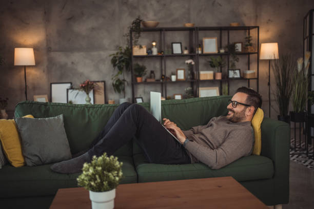 istock Young handsome male freelancer working on laptop at home while sitting comfortably on his sofa 2152641064