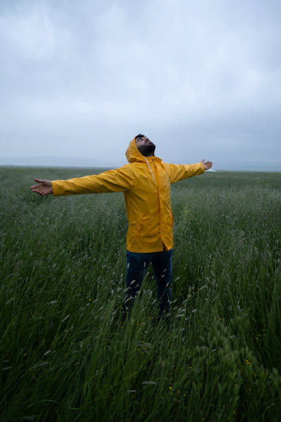 istock Carefree man in raincoat having fun in nature. 2152642271