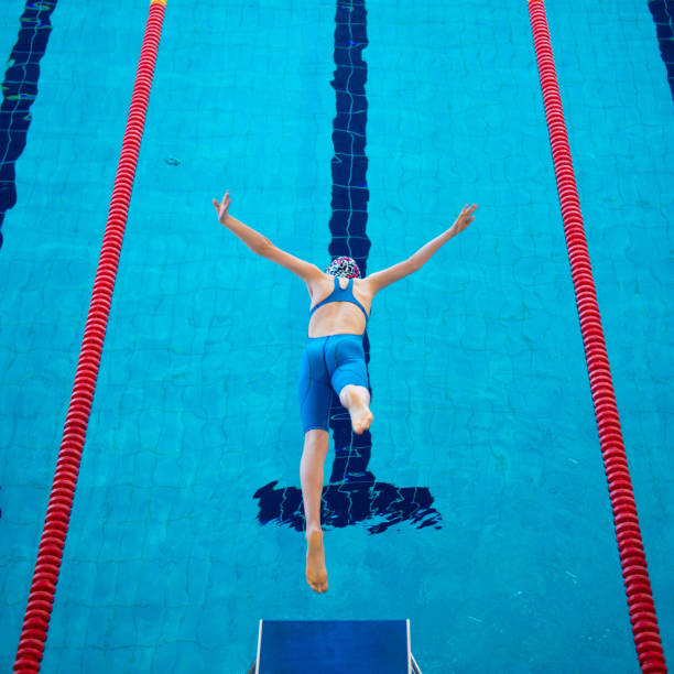Swimmer girl start from the starting table in the pool