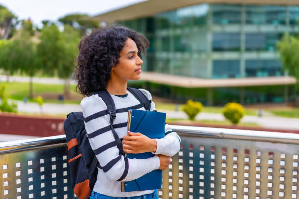 istock Latin woman standing holding a folder outside the university campus 2152645426