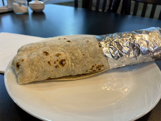 istock Delicious Wrapped Burrito in Foil on White Plate 2152652525