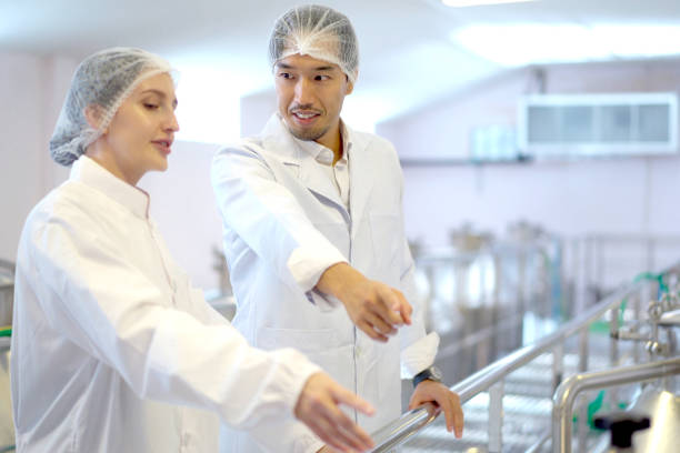 istock Scientists working - examining machines in factory. 2152660395