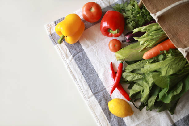 istock An eco-friendly reusable shopping bag filled with multi-colored fresh vegetables and groceries on the kitchen counter at home, representing the concept of zero waste and a sustainable lifestyle 2152663933