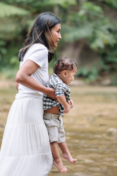 Modern Young mother with a small daughter enjoyg camp at park exploring nature