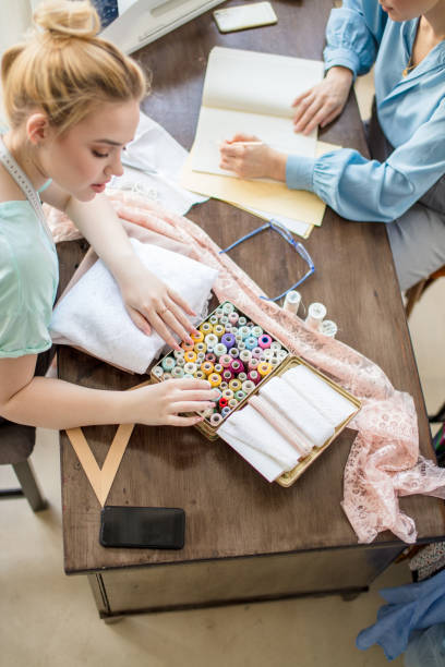 istock two dressmaker looks at a nice piece of fabric 2152667948
