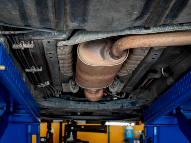 istock Bottom view of exhaust pipe under the car while lifted vehicle check-up maintenance service. A part of metal exhaust muffler pipe with rust stains in garage for repair and fix at automotive workshop. 2152673049