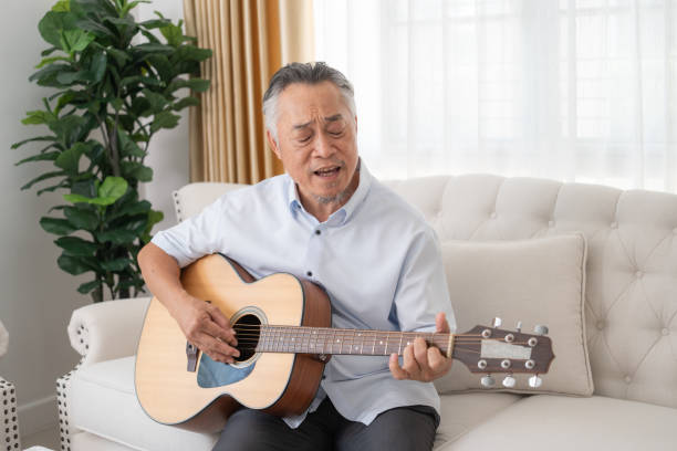 istock Senior Man Playing Guitar on Couch. 2152674625