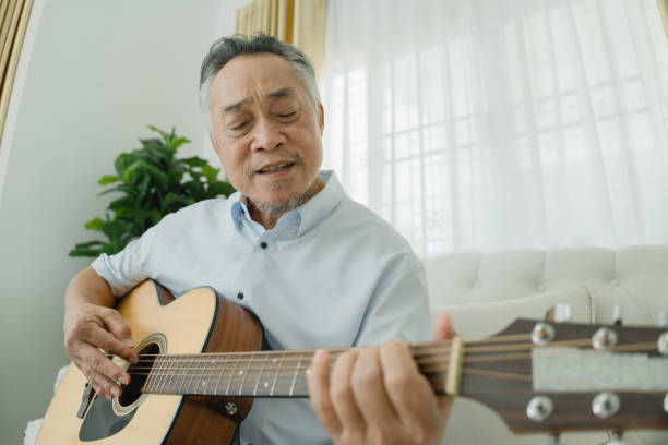 istock Senior Man Playing Guitar on Couch. 2152674626