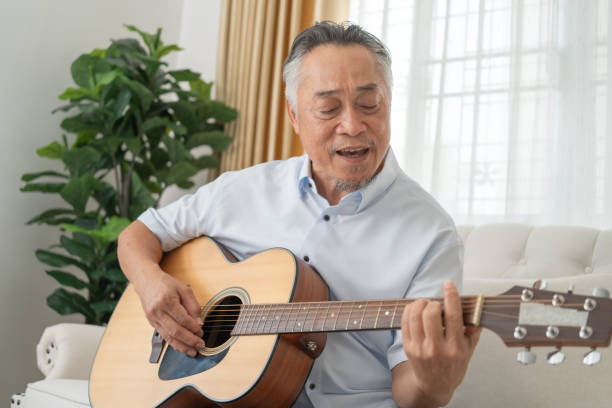 istock Senior Man Playing Guitar on Couch. 2152674629