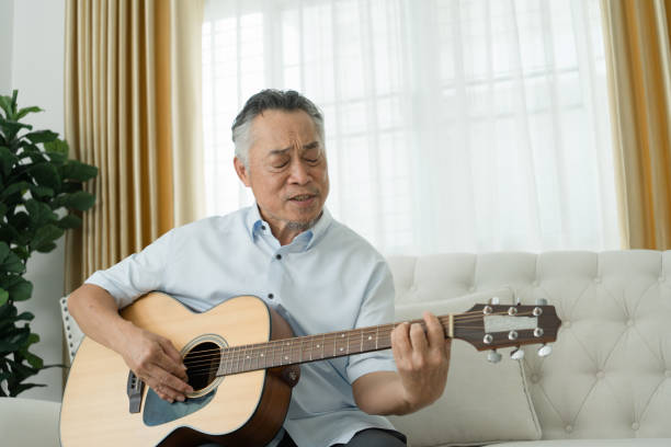istock Senior Man Playing Guitar on Couch. 2152674634