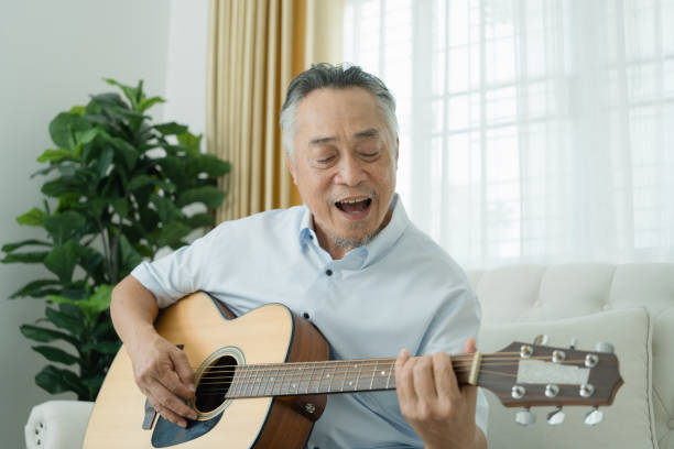 istock Senior Man Playing Guitar on Couch. 2152674635