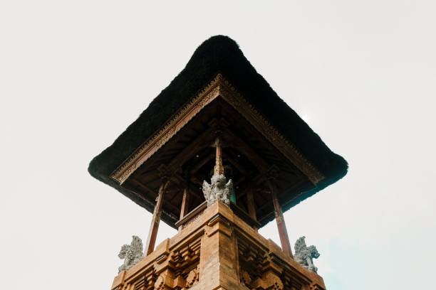 Balinese Hindu temple with black straw rooftop against white sky made of bricks