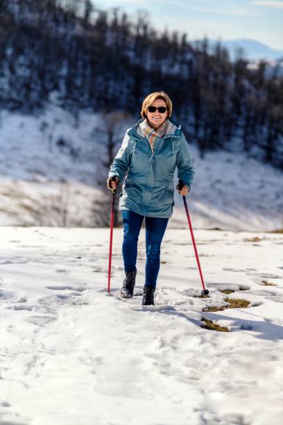 istock Mature woman walks down snowy track 2152680018