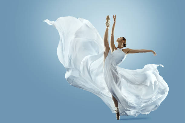istock Ballerina doing Split in White flying Dress. Ballet Dancer jumping over Blue background. Freedom and Inspiration Concept. Carefree Beautiful Woman dancing in silk Gown 2152681618
