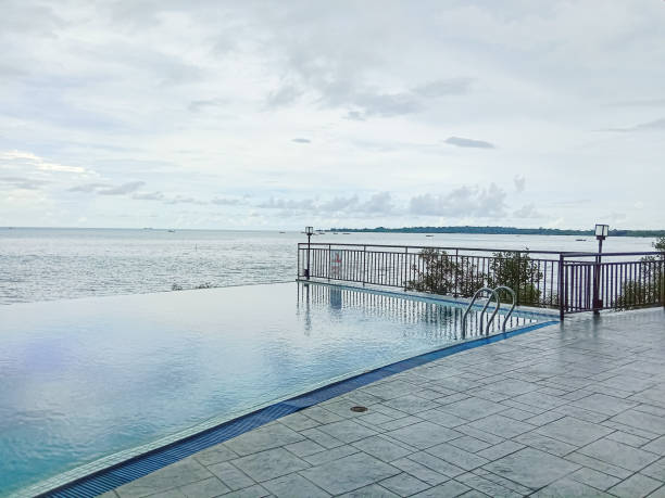 Infinity swimming pool side with sea view background. Infinity poolside, tropical sea. Summer vacation concept.