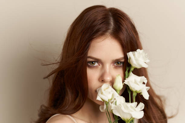 istock Woman with white flowers on beige background brunette model 2152683478