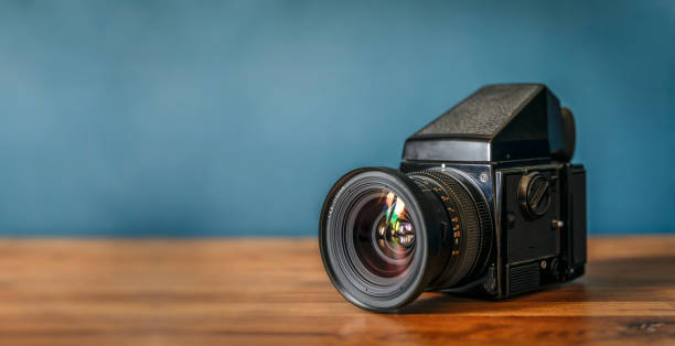 istock Camera is on the table. Medium format analog film camera on a blank background. Retro vintage technology style 2152684856