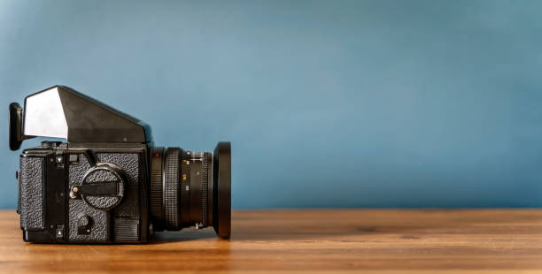 istock Camera is on the table. Medium format analog film camera on a blank background. Retro vintage technology style 2152684903