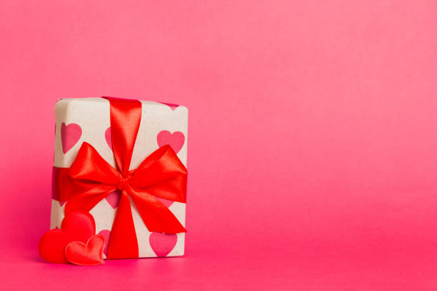 istock gift box with red bow and red heart on colored background. Perspective view. Flat lay 2152685985