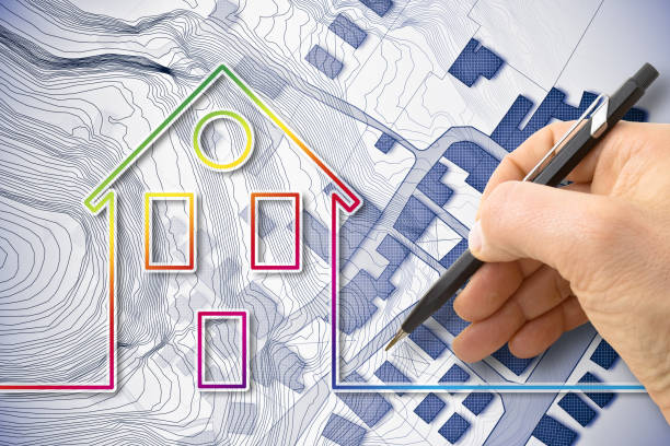 istock Architect drawing a residential building over an imaginary cadastral map of territory with buildings, fields and roads 2152686417