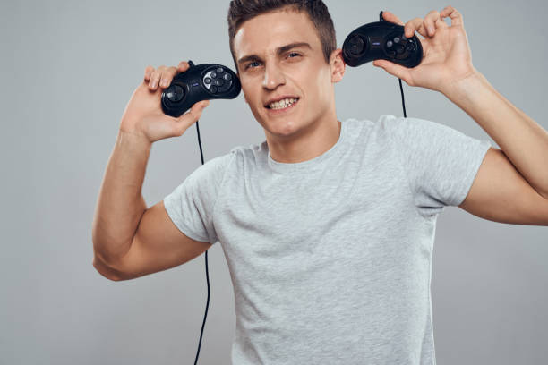 istock A man with controllers in his hands near his head technology video games entertainment light background 2152688253