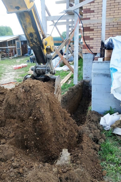 istock The excavator digs a small trench in the yard. 2152688442