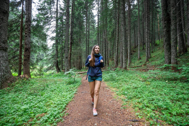 istock Young smiling woman walking on footpath in the forest 2152690757