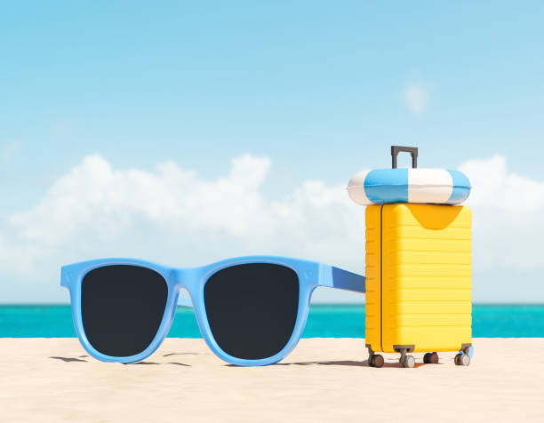 istock Suitcase and sunglasses standing on beach 2152691817