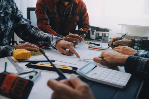 istock engineer people meeting working and pointing at a drawings in office for discussing. Engineering tools and construction concept. 2152692019