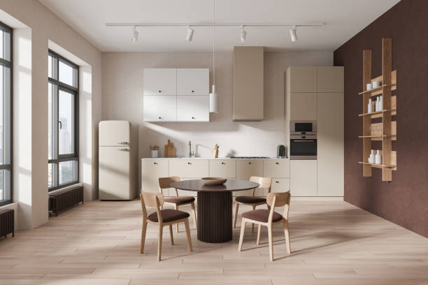 istock Beige home kitchen interior with dining table and cooking cabinet, window 2152692130
