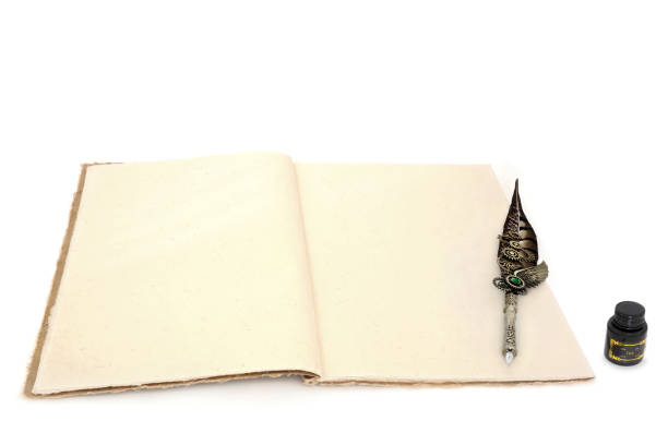 Retro writing equipment with feather quill nib pen, hemp notebook and black ink bottle on white background. Old fashioned letter, document, journal, manuscript concept.