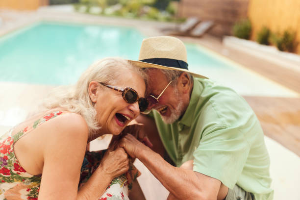 istock Cheerful senior couple laughing in summer day at poolside. 2152692801