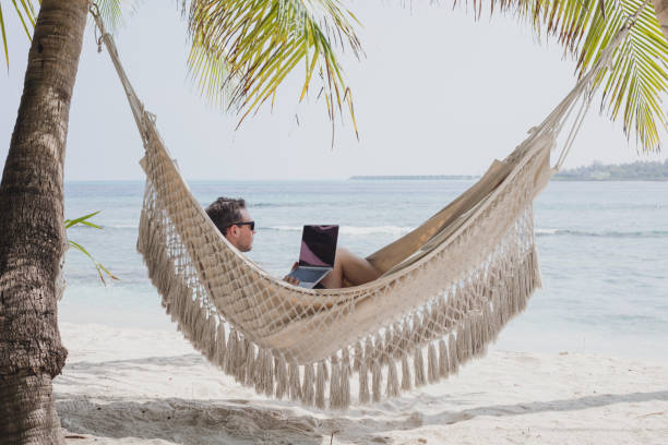 istock freelance job, teleworking or banking online, man with computer in hammock 2152693352