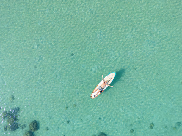 istock Man lying down on a floating paddleboard with arms outstretched 2152693472