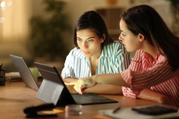 istock Two tele workers talking about work in the night at home 2152693650