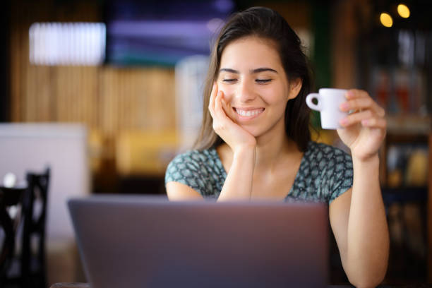 istock Happy woman holding coffee using laptop in a restaurant 2152693746