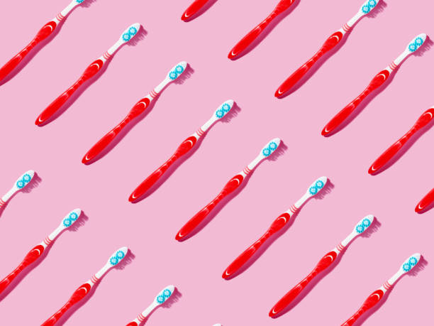 istock Repetitive pattern of toothbrushes on pink background. 2152694262