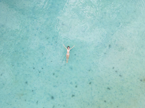 istock A Young Woman Floating in Crystal Clear Waters 2152699597