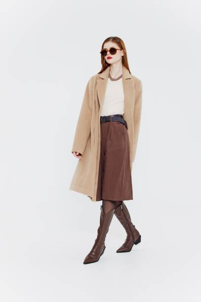istock A red-haired lady in a coat on a white background. Full-length shot 2152701184