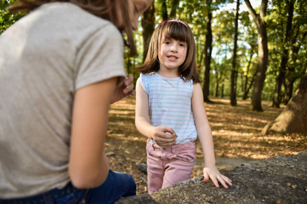 Two happy girls playing in public park at autumn day