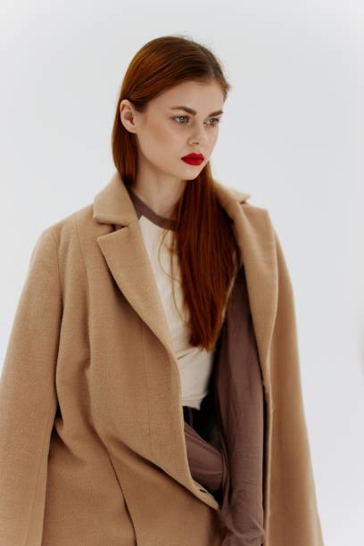 istock Professional redhead model posing on a white background in a coat. Advertising for brands showrooms catalog of clothing for women 2152702679