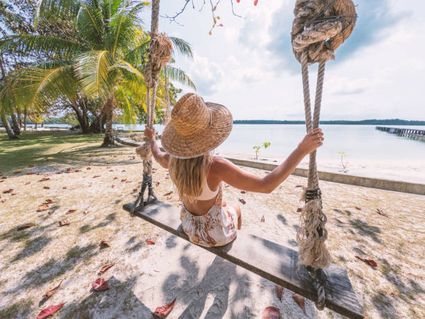 istock Relaxing on a Swing at a Tropical Beach 2152703823