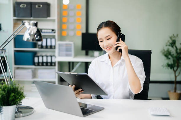 istock Asian businesswoman working with working notepad, tablet and laptop documents talking on the smartphone, tablet and laptop video call tax 2152704728