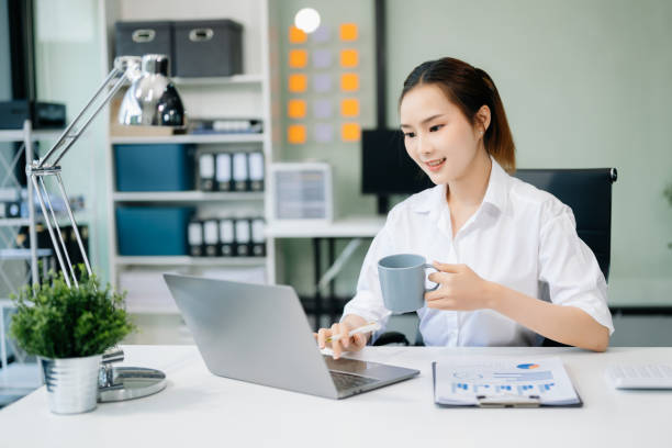 istock Asian businesswoman working with working notepad, tablet and laptop documents talking on the smartphone, tablet and laptop video call tax 2152704729