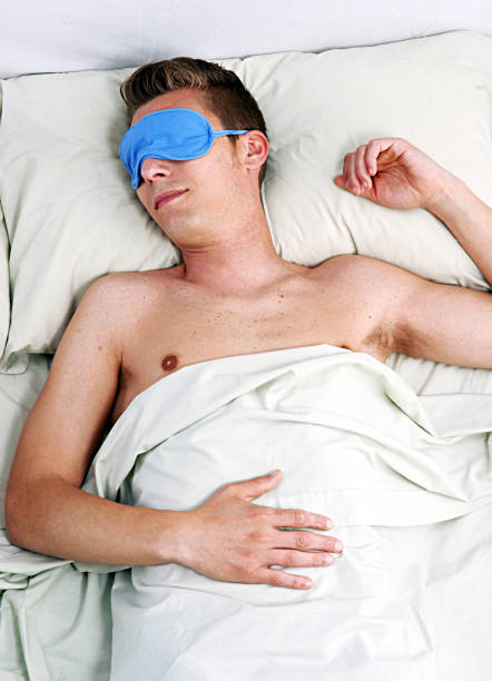 istock Man sleeping on bed wearing eye mask. 2152705422