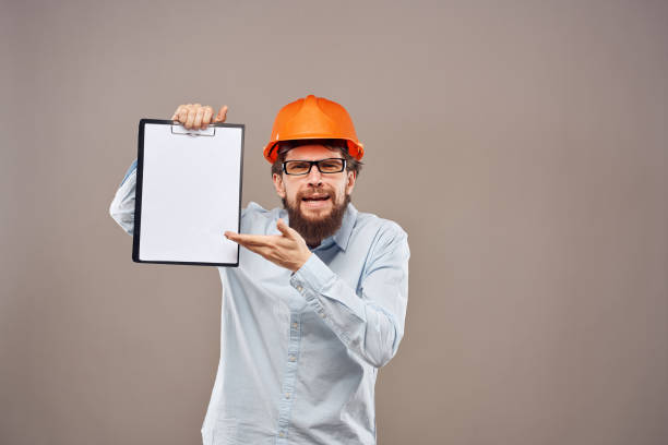 istock A man in a shirt with an orange hard hat engineer work documents rendering services 2152706398