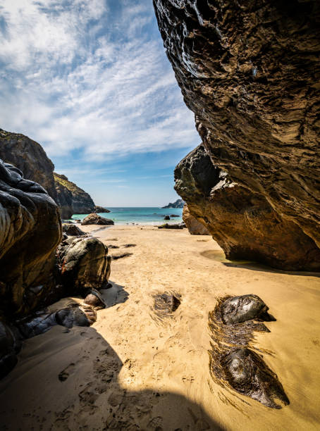 Wide aerial view of clear turquoise ocean dotted with small rocky islets near Quiberon, under a bright blue sky. The scene is open and sunlit, with gentle ripples and a tranquil atmosphere.
